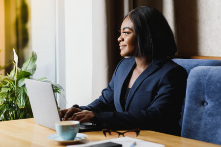 happy young african american businesswoman using computer in officeの写真素材