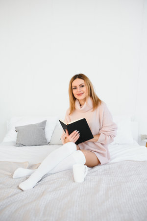 beautiful woman reading book in the bed. Relaxing conceptの写真素材