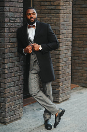 Fashion portrait of a handsome young African American business man walking outdoors in a casual pose.の写真素材