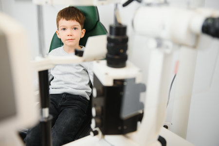 Boy checks eye vision in ophthalmology clinicの写真素材
