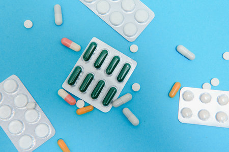 Top view of medicines, work tools and accessories doctor, nurse. Medical set - Tablets, thermometer, syringe, ampoules, adhesive plaster and statoscope on a blue background. flat layの写真素材
