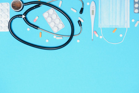 Scattered white pills on blue table.Medical, pharmacy and healthcare concept. Blue background white...