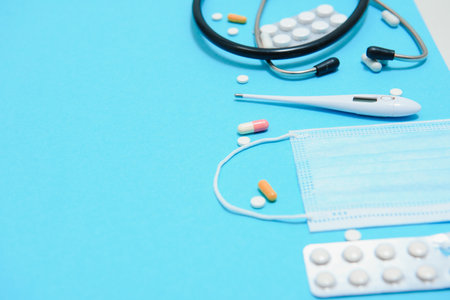 Scattered white pills on blue table.Medical, pharmacy and healthcare concept. Blue background white...