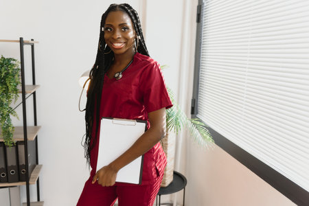 Portrait Of Smiling Female Doctor Wearing White Coat With Stethoscope In Hospital Officeの写真素材