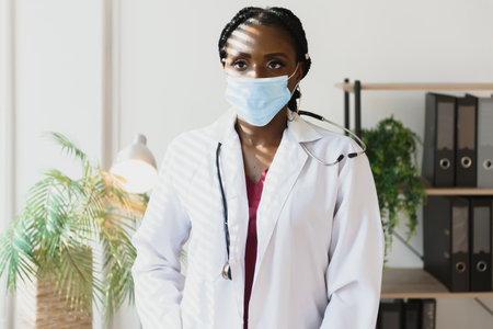 Close up portrait of African American happy female healthcare specialist in medical mask.
