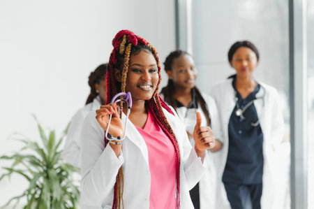 health care, profession, people and medicine concept - happy African American female doctor or nurse over group of medics meeting at hospitalの写真素材