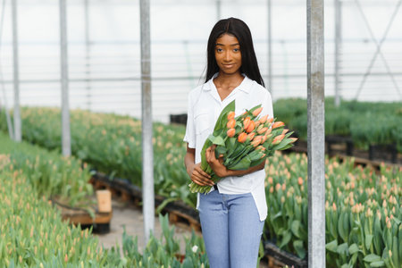 pretty young african gardener portrait in greenhouseの写真素材