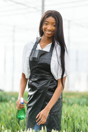 pretty young african gardener portrait in greenhouse