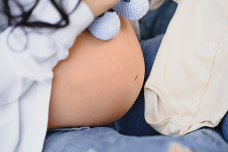 Pregnant Woman holding her hands in a heart shape on her baby bump. Pregnant Belly with fingers Heart symbol. Maternity concept. baby showerの写真素材