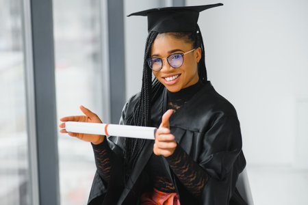 cheerful african american graduate student with diploma in her hand