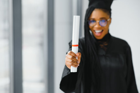 Closeup portrait of happy female student with certificate in college campusの写真素材