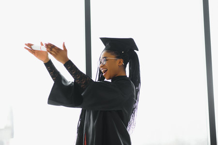 pretty african female college graduate at graduationの写真素材