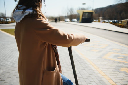 Young beautiful woman riding an electric scooter to work, modern girl, new generation, electric transport, ecology, ecological transport, sunset, electric skateboard.の写真素材