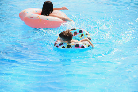 Happy child and woman playing in swimming pool. summer vacation conceptの写真素材