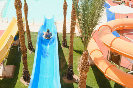 little boy sliding on the swimming pool