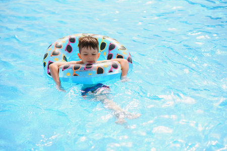 Happy child playing in swimming pool. summer vacation concept