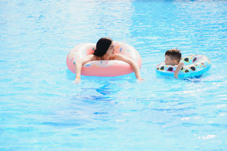 Happy child and woman playing in swimming pool. summer vacation conceptの写真素材