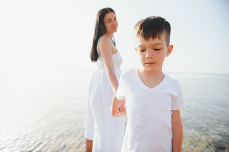 Mother and son playing on the beach at the day time. Concept of friendly family.の写真素材