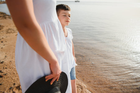 mother and son walking on sunset beachの写真素材