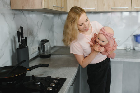 Woman cooking with her little daughter in handsの写真素材