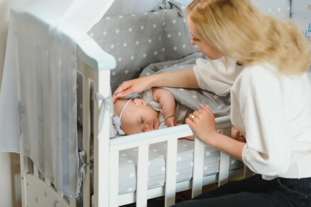 Young mother with their newborn baby near bed cat