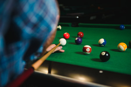 Thoughtful man plays billiards. Billiard room on the background.