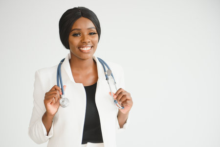 Portrait Of Smiling Female Doctor Wearing White Coat With Stethoscope In Hospital Officeの写真素材