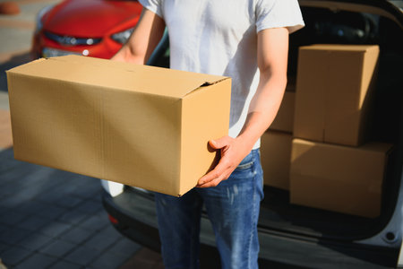 Deliveryman holds parcels at the car, deliveringの写真素材