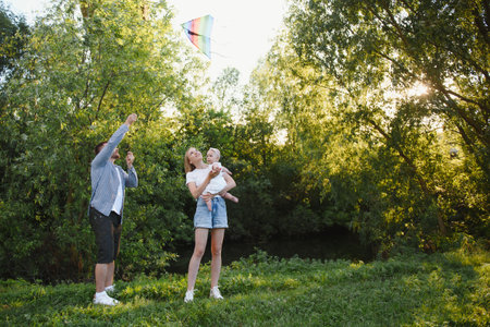 Happy young family spending time together outside in green nature.の写真素材