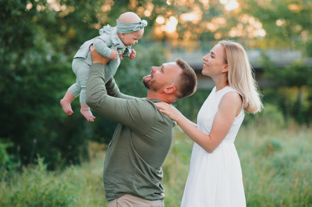 Happy young family spending time together outside in green nature.