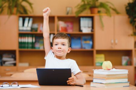 school boy using tablet computer in classroom