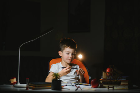 boy doing homework at home in the evening