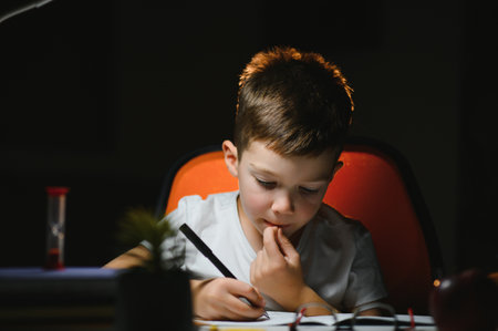 boy doing homework at home in the evening