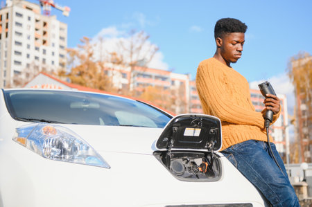 African American man charging his electric car.の写真素材