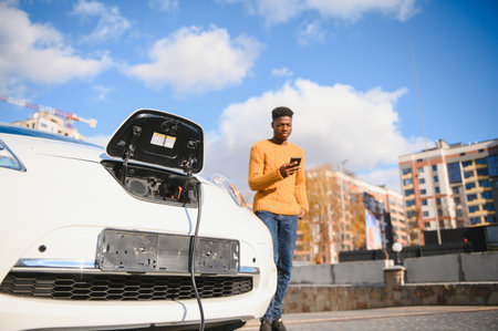 African American man charging his electric car.の写真素材