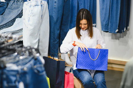 Beautiful female looking jeans in the boutiqueの写真素材