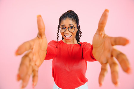 Photo of funny dark skinned young woman isolated over pink background.の写真素材