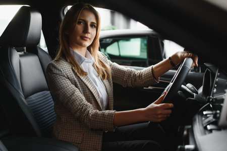 Photo of happy young woman sitting inside her new car. Concept for car rentalの写真素材