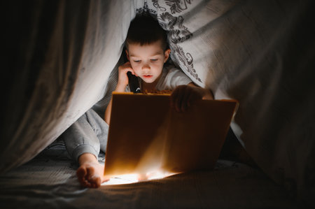 Child reading book in bed. Kids read at night. Little boy with fairy tale books in the bedroom....