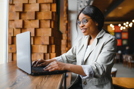 Very happy African-Americam woman reading exciting news onlineの写真素材