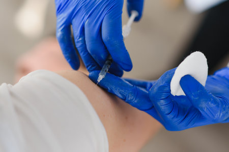 Female doctor making injection using syringe to male patient in hospital. senior man taking...