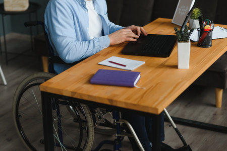 Man in wheelchair at home or in officeの写真素材