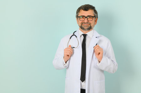 Professional Doctor Man In White Uniform Posing on Blue Studio Background. Panorama With Copy Spaceの写真素材