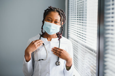 Portrait Of Smiling Female Doctor Wearing White Coat With Stethoscope In Hospital Officeの写真素材
