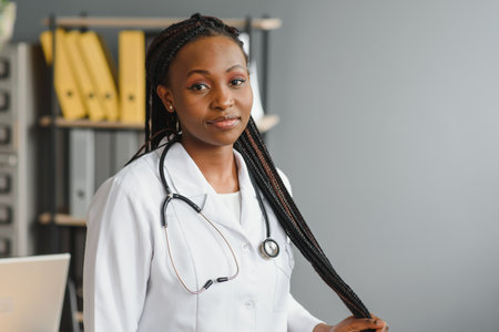 Portrait Of Smiling Female Doctor Wearing White Coat With Stethoscope In Hospital Officeの写真素材