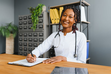 Portrait Of Smiling Female Doctor Wearing White Coat With Stethoscope In Hospital Officeの写真素材