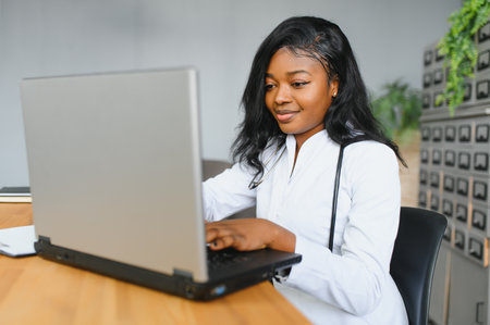 healthcare, medical and technology concept - african female doctor with laptop.の写真素材