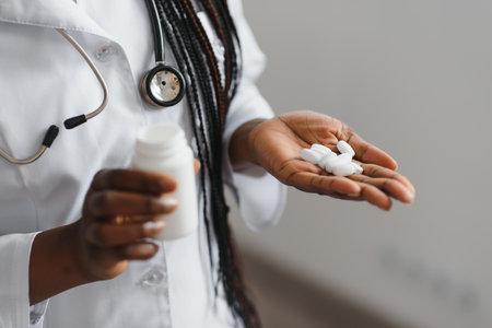 Close up cropped horizontal shot of female doctor or pharmacist, holding colorful blisters with pillsの写真素材
