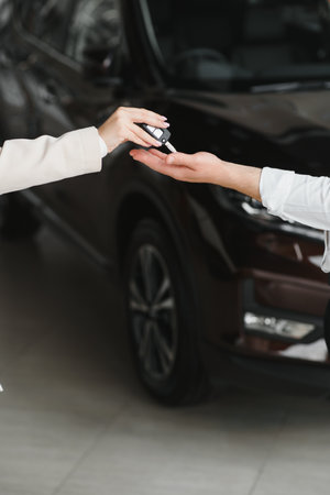businessman exchange handing over the car keys for to a young womenの写真素材
