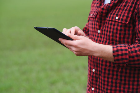 A young farmer inspects the quality of wheat sprouts in the field. The concept of agriculture.の写真素材